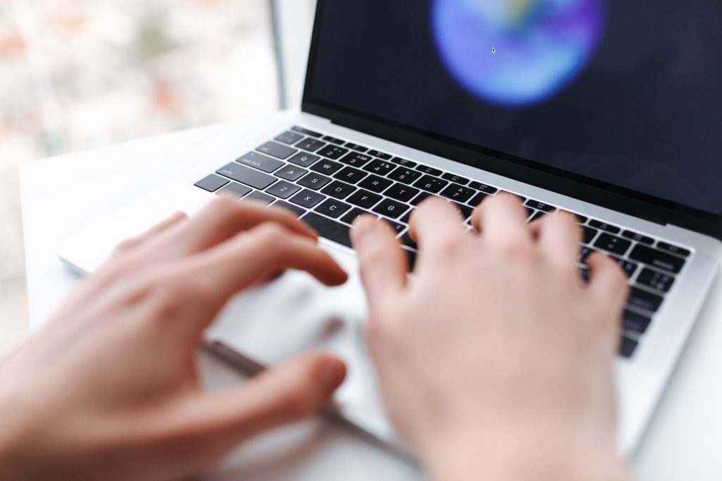 Photo of man hands typing on laptop